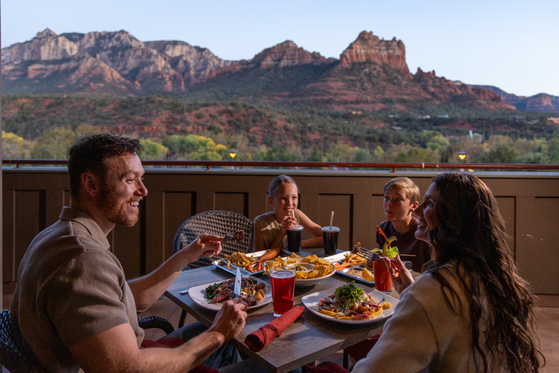 Guest enjoying dinner at Open Range Grill and Taven with a view of the red rock formations in the horizon.